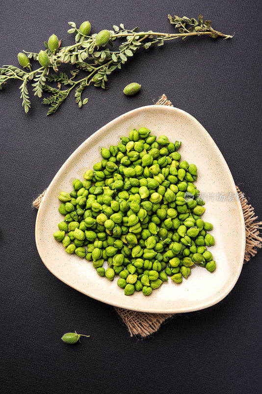 新鲜的绿色鹰嘴豆或鹰嘴豆在印地语中也被称为harbara或harhara, Cicer是科学名称，盛在一个木碗或盘子里。有选择性的重点